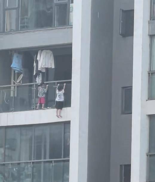 吓人！幼童爬到13层阳台外悬空玩“引体向上”，街道办：已告诫家长加强看护